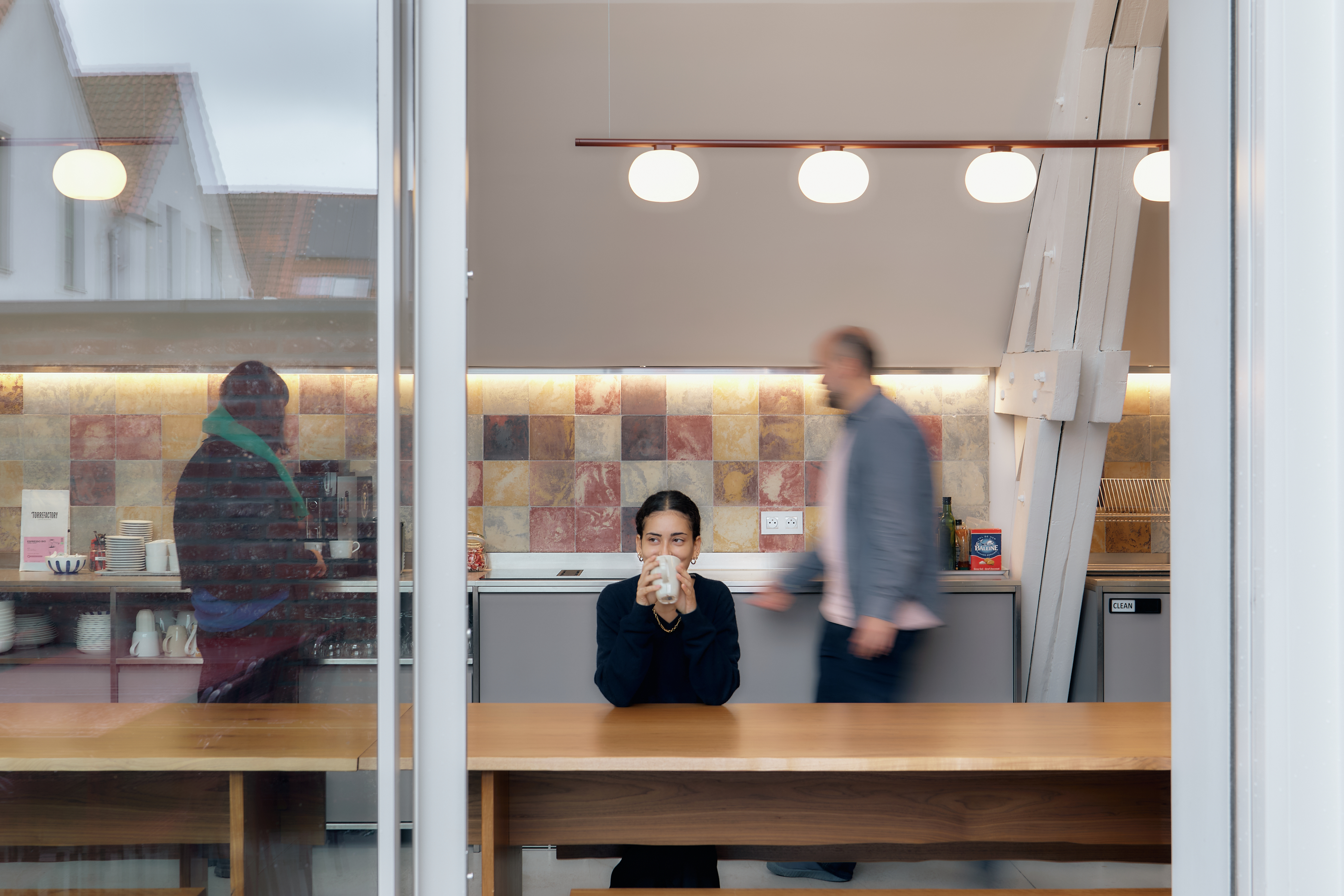 Spacious industrial office interior with high ceilings, exposed brick walls, and open workspace areas.